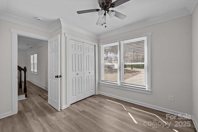 7219 Spring Morning Ln, Charlotte, NC 28227 - unfurnished bedroom featuring multiple windows, wood finished floors, a closet, ornamental molding, and ceiling fan