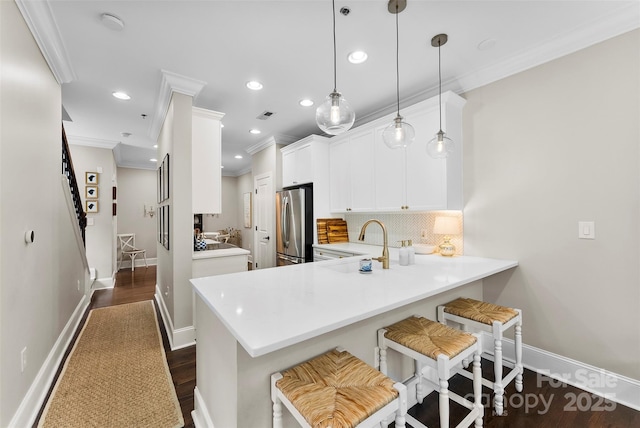 106 N Laurel Ave Unit 118, Charlotte, NC 28207 - kitchen featuring freestanding refrigerator, crown molding, a breakfast bar area, tasteful backsplash, and recessed lighting