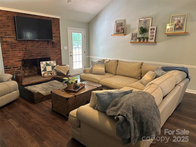 3210 Crow Row, Monroe, NC 28112 - living room with dark wood finished floors, lofted ceiling, a brick fireplace, and a textured ceiling