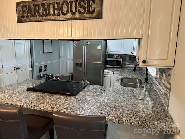 3210 Crow Row, Monroe, NC 28112 - kitchen featuring appliances with stainless steel finishes, dark stone countertops, a breakfast bar area, and backsplash