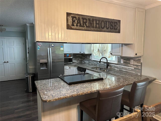 3210 Crow Row, Monroe, NC 28112 - kitchen with stainless steel appliances, a peninsula, tasteful backsplash, dark stone countertops, and ornamental molding