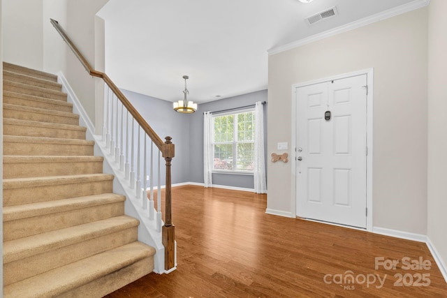 159 E Warfield Dr, Mooresville, NC 28115 - foyer entrance featuring stairs, wood finished floors, a chandelier, and ornamental molding