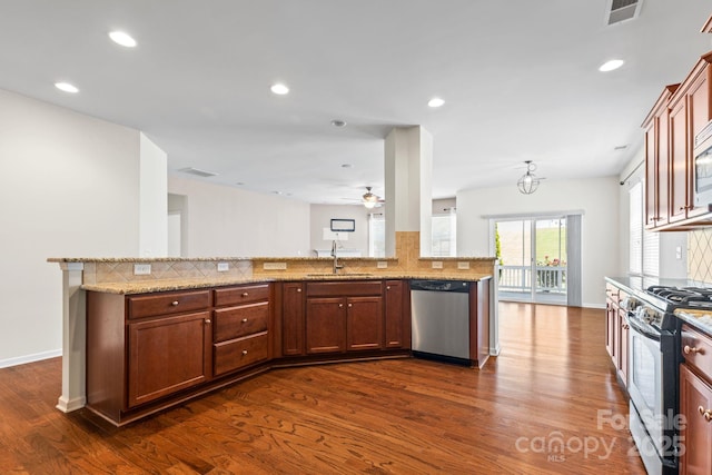 159 E Warfield Dr, Mooresville, NC 28115 - kitchen with appliances with stainless steel finishes, backsplash, dark wood-style floors, a ceiling fan, and light stone counters