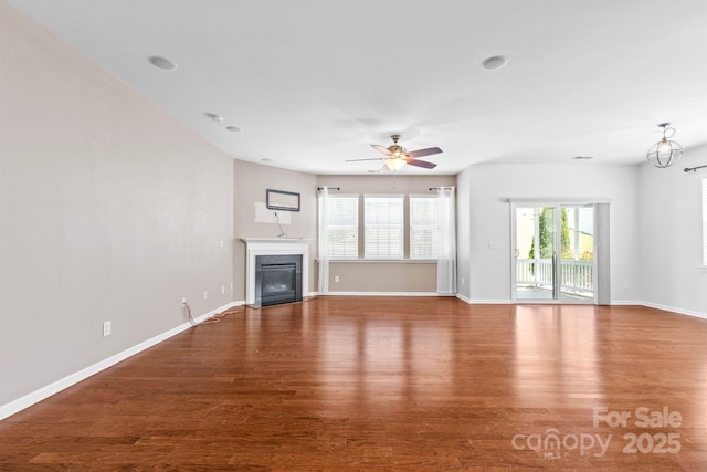 159 E Warfield Dr, Mooresville, NC 28115 - unfurnished living room featuring healthy amount of natural light, wood finished floors, a fireplace with flush hearth, and ceiling fan