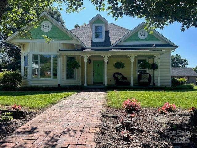 743 S College Ave, Newton, NC 28658 - victorian-style house with a porch, a front yard, and roof with shingles