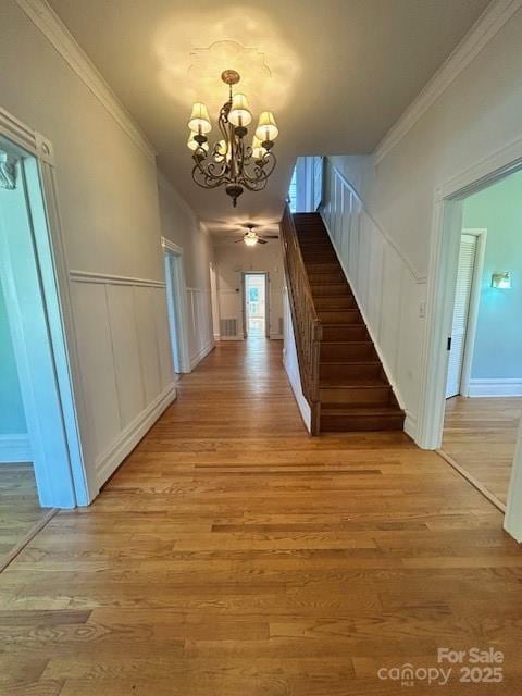 743 S College Ave, Newton, NC 28658 - foyer entrance featuring a chandelier, light wood-style floors, stairway, ornamental molding, and wainscoting