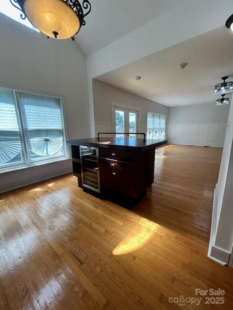 743 S College Ave, Newton, NC 28658 - kitchen with dark countertops, light wood-style floors, wainscoting, a decorative wall, and open floor plan