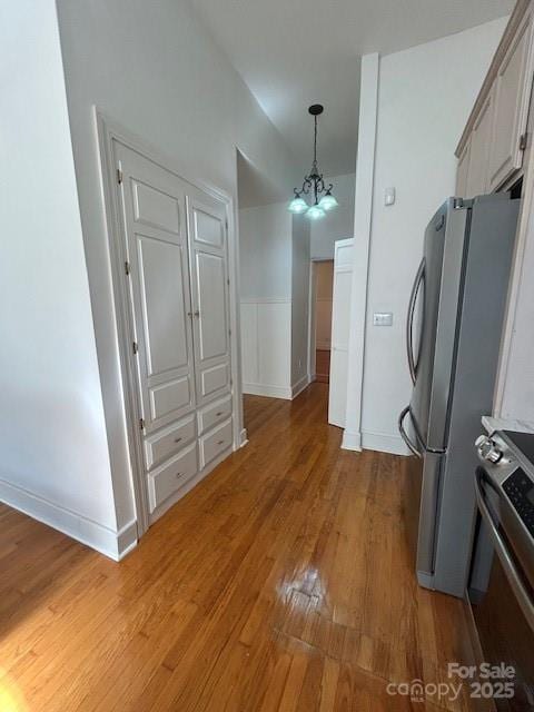743 S College Ave, Newton, NC 28658 - kitchen featuring appliances with stainless steel finishes, light wood-style floors, a chandelier, hanging light fixtures, and wainscoting