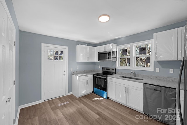 1229 Jenkins St, Rock Hill, SC 29732 - kitchen featuring stainless steel appliances, white cabinetry, light wood-style floors, and light stone counters