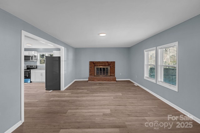 1229 Jenkins St, Rock Hill, SC 29732 - unfurnished living room featuring wood finished floors and a brick fireplace