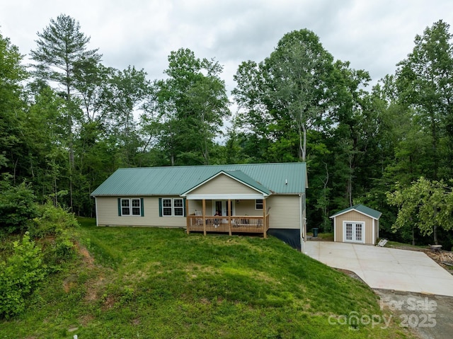 1036 Williamsburg Dr, Lenoir, NC 28645 - ranch-style home featuring a front lawn, a metal roof, french doors, an outdoor structure, and concrete driveway
