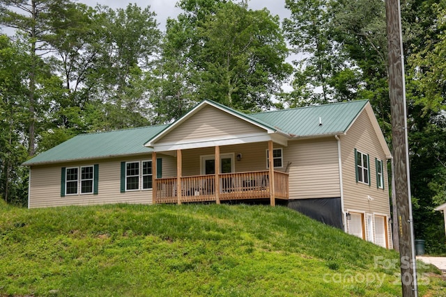 1036 Williamsburg Dr, Lenoir, NC 28645 - view of front of home with an attached garage, a metal roof, driveway, covered porch, and a front lawn