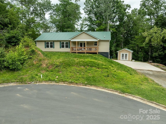 1036 Williamsburg Dr, Lenoir, NC 28645 - ranch-style house featuring french doors, a front yard, a metal roof, view of scattered trees, and driveway