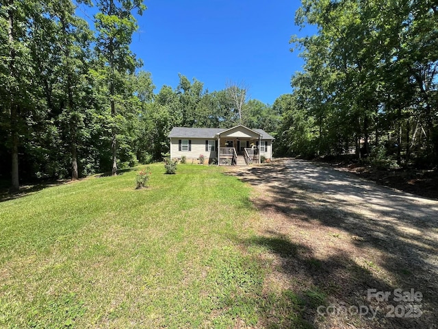 5550 Hillsdale St, Fort Lawn, SC 29714 - view of front facade with a porch, a front lawn, dirt driveway, and a forest view