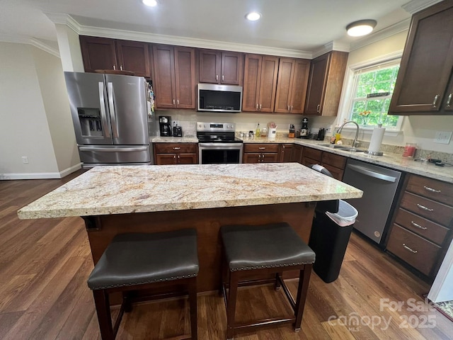 5550 Hillsdale St, Fort Lawn, SC 29714 - kitchen with appliances with stainless steel finishes, ornamental molding, dark wood-type flooring, a breakfast bar, and light stone countertops