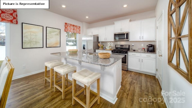 119 Rustling Waters Dr, Mooresville, NC 28117 - kitchen with stainless steel appliances, dark wood finished floors, tasteful backsplash, white cabinetry, and recessed lighting