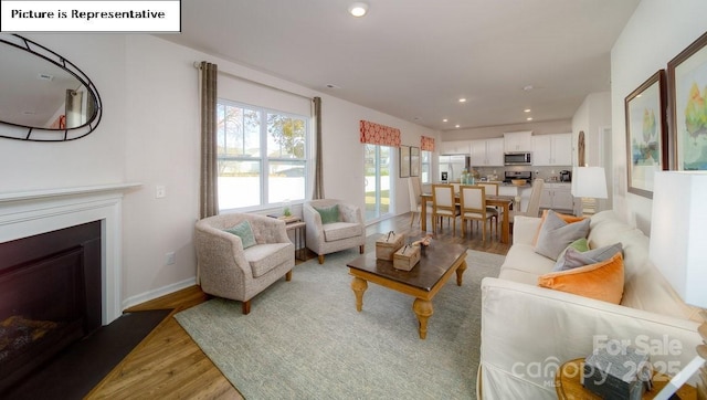 119 Rustling Waters Dr, Mooresville, NC 28117 - living area featuring light wood-type flooring, recessed lighting, and a fireplace with flush hearth