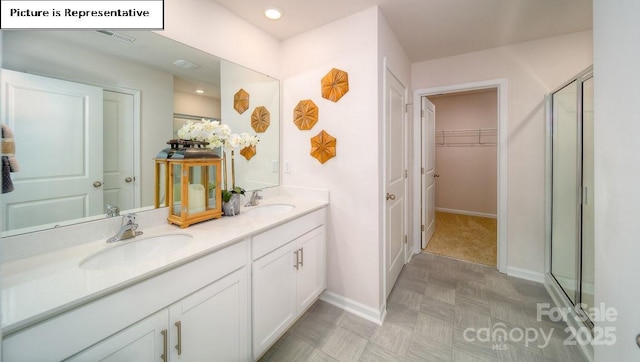 119 Rustling Waters Dr, Mooresville, NC 28117 - bathroom with double vanity, a stall shower, a walk in closet, and recessed lighting