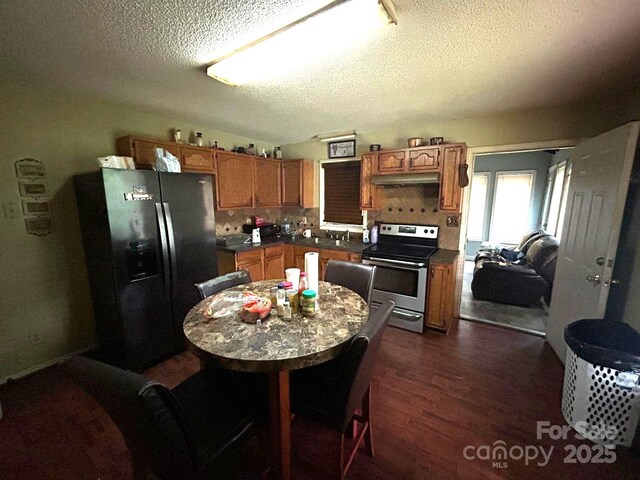 407 Alton St, Monroe, NC 28110 - kitchen with refrigerator with ice dispenser, stainless steel electric range oven, a textured ceiling, dark wood-style floors, and dark countertops