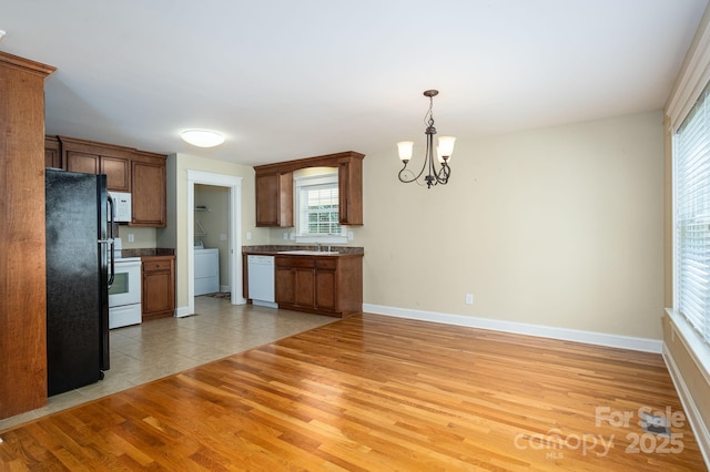 110 Leeper Ave, Belmont, NC 28012 - kitchen featuring white appliances, washer / clothes dryer, a chandelier, light wood-type flooring, and pendant lighting