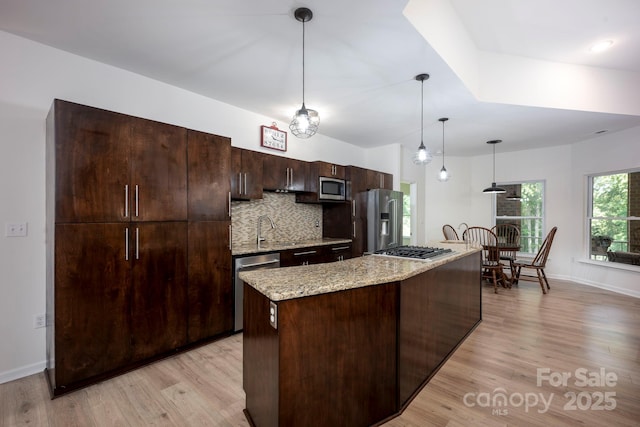 3595 Lake Bluff Dr, Sherrills Ford, NC 28673 - kitchen featuring appliances with stainless steel finishes, light wood-style floors, dark brown cabinetry, tasteful backsplash, and a kitchen island
