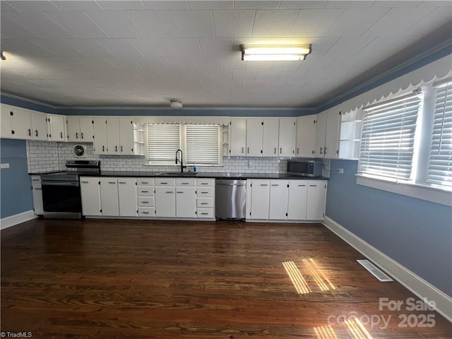 820 Suncrest Orchard Rd, North Wilkesboro, NC 28659 - kitchen with appliances with stainless steel finishes, dark countertops, backsplash, and dark wood finished floors