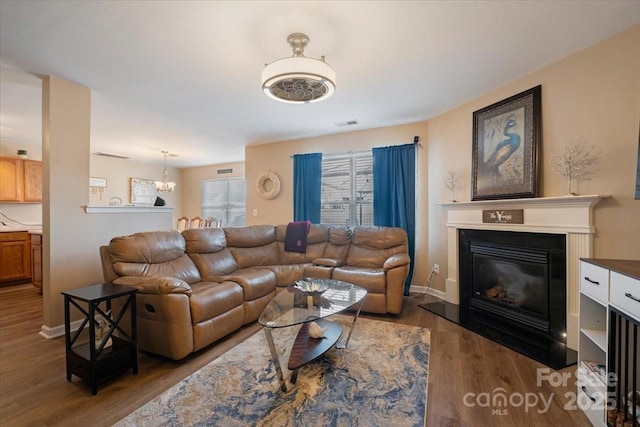 6340 Ziegler Ln Unit 148-A, Charlotte, NC 28269 - living area featuring a glass covered fireplace, wood finished floors, and a chandelier