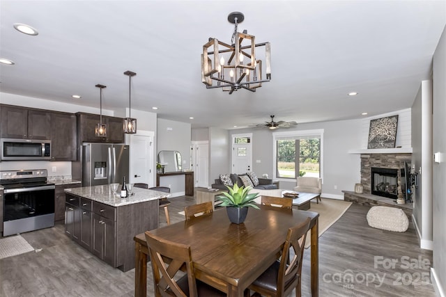11 S Pine Dr, Weaverville, NC 28787 - dining room featuring dark wood-type flooring, a chandelier, recessed lighting, a ceiling fan, and a stone fireplace