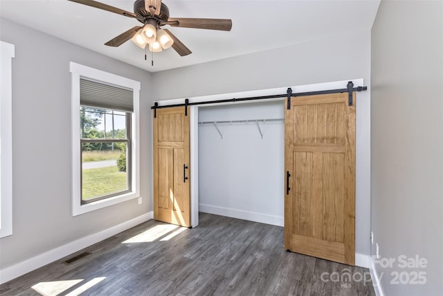 11 S Pine Dr, Weaverville, NC 28787 - unfurnished bedroom featuring a barn door, dark wood-type flooring, ceiling fan, and a closet