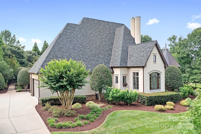 114 Thurstons Way, Mooresville, NC 28117 - view of front facade with stucco siding, a chimney, an attached garage, concrete driveway, and a shingled roof