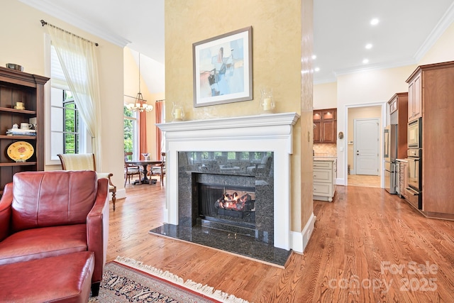 114 Thurstons Way, Mooresville, NC 28117 - living room featuring light wood-style floors, crown molding, a high end fireplace, recessed lighting, and a chandelier