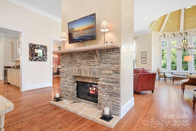 114 Thurstons Way, Mooresville, NC 28117 - living room with crown molding, a stone fireplace, light wood-style flooring, a chandelier, and a towering ceiling