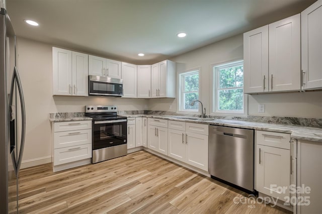 835 Vine Arden Rd, Morganton, NC 28655 - kitchen with appliances with stainless steel finishes, light wood-style flooring, light stone countertops, recessed lighting, and white cabinetry