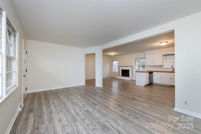 4601 Mendham Dr, Charlotte, NC 28215 - unfurnished living room with a fireplace with raised hearth and light wood finished floors