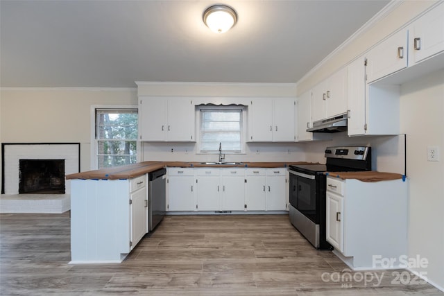 4601 Mendham Dr, Charlotte, NC 28215 - kitchen featuring stainless steel appliances, under cabinet range hood, a peninsula, wood counters, and ornamental molding