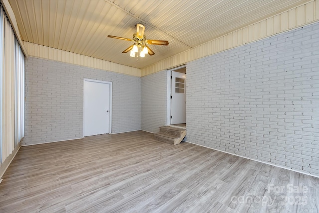 4601 Mendham Dr, Charlotte, NC 28215 - spare room with brick wall, light wood finished floors, and a ceiling fan