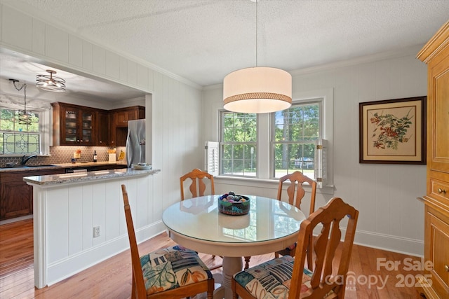 747 9th St NW, Hickory, NC 28601 - dining space featuring light wood-type flooring, ornamental molding, and a textured ceiling