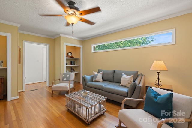 747 9th St NW, Hickory, NC 28601 - living room featuring a ceiling fan, light wood-type flooring, a textured ceiling, built in shelves, and ornamental molding