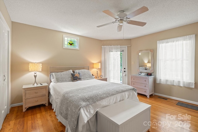 747 9th St NW, Hickory, NC 28601 - bedroom with light wood-type flooring, access to exterior, ceiling fan, and a textured ceiling
