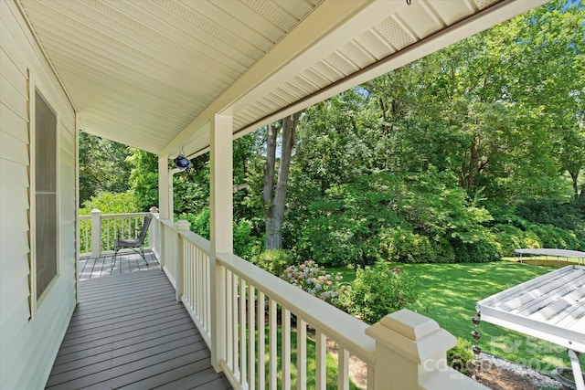 747 9th St NW, Hickory, NC 28601 - wooden porch with a trampoline, a yard, and view of wooded area