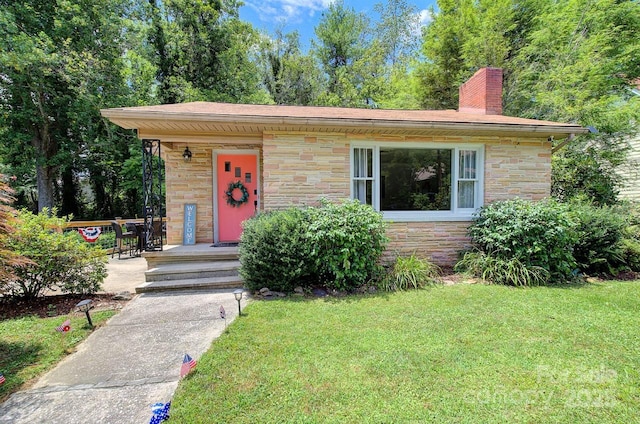 207 Buncombe St, Hendersonville, NC 28739 - view of front of property with stone siding, a front lawn, a chimney, and a porch
