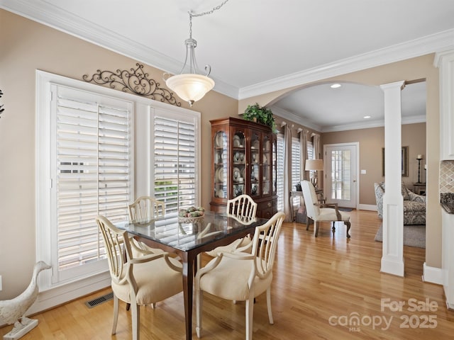 5572 Yorke St NW, Concord, NC 28027 - dining space with arched walkways, decorative columns, light wood-style floors, crown molding, and recessed lighting
