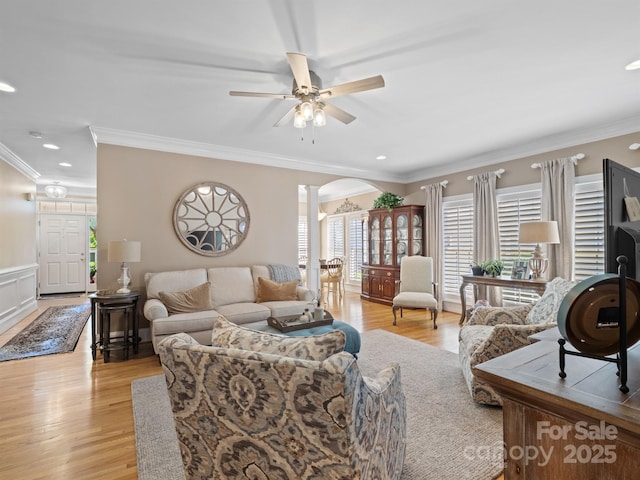5572 Yorke St NW, Concord, NC 28027 - living room featuring arched walkways, decorative columns, a ceiling fan, crown molding, and light wood-type flooring