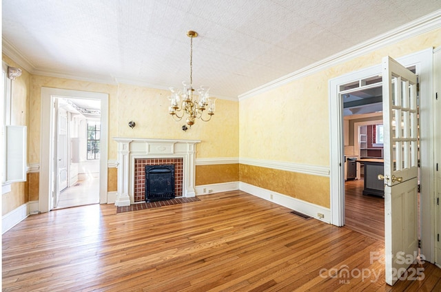 1010 College Ave SW, Lenoir, NC 28645 - unfurnished living room featuring wood-type flooring, a chandelier, ornamental molding, and a tiled fireplace