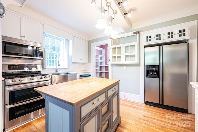 1010 College Ave SW, Lenoir, NC 28645 - kitchen with appliances with stainless steel finishes, wood counters, backsplash, white cabinetry, and light wood-style flooring