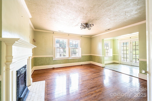 1010 College Ave SW, Lenoir, NC 28645 - unfurnished living room with healthy amount of natural light, wood finished floors, a fireplace with flush hearth, a textured ceiling, and french doors