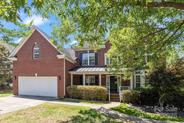 6800 Augustine Way, Charlotte, NC 28270 - traditional home with a porch, an attached garage, brick siding, driveway, and a standing seam roof