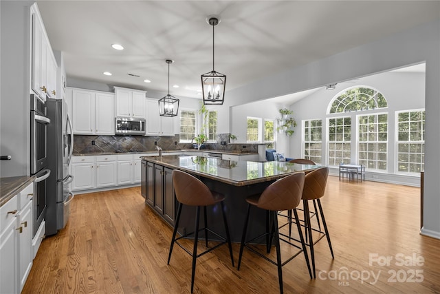 6800 Augustine Way, Charlotte, NC 28270 - kitchen featuring appliances with stainless steel finishes, dark countertops, a breakfast bar area, healthy amount of natural light, and recessed lighting
