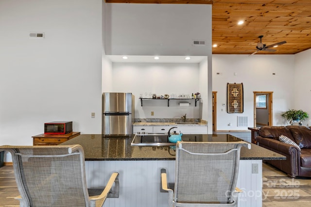 442 Blantyre Church Rd, Horse Shoe, NC 28742 - kitchen featuring freestanding refrigerator, ceiling fan, a towering ceiling, white cabinets, and light wood-style floors