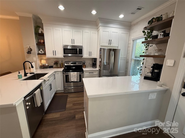 1013 Park W Dr Unit 5, Charlotte, NC 28209 - kitchen with open shelves, stainless steel appliances, a peninsula, ornamental molding, and white cabinets